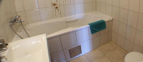 a white bathroom with a tub and a toilet at Vila Vinka Tito in Igrane