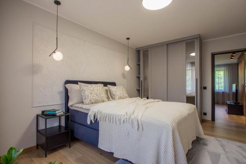 a bedroom with a bed with a blue and white bedspread at Uus Street Apartment, Modern Stay near City Centre with Free Parking in Tartu