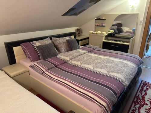 a bedroom with a large bed and a mirror at Apartmani Hrastik 2 in Bihać