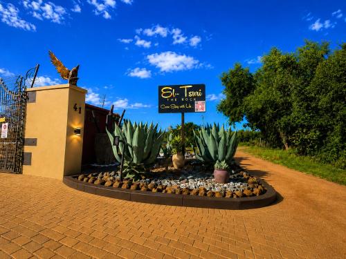 a sign in front of a building with plants at Hartbeespoort - El-Tsuri Guest Resort in Hartbeespoort