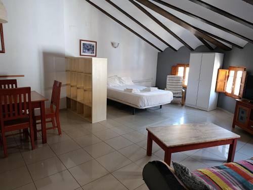 a bedroom with a bed and a table and chairs at Complejo Rural La Belluga in Segorbe