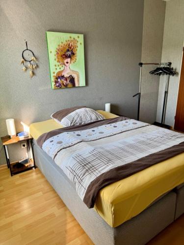 a bedroom with a bed with a painting on the wall at Gemütliche Apartments in Bendorf