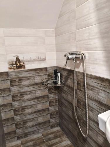 a bathroom with a shower with wooden tiles at Miliő Apartman Sarud in Sarud