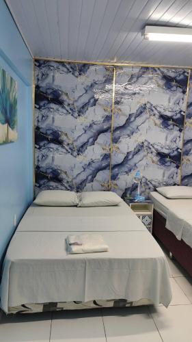 a bed in a room with a blue wall at House of Colors Hotel in Manaus