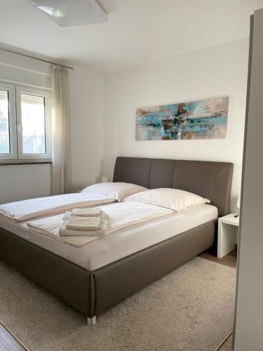 a large bed in a white room with a bed frame at Apartman Orkic in Vodnjan