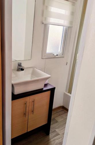 a bathroom with a white sink and a window at Bungalow, Sueños del Sur! in Chiclana de la Frontera