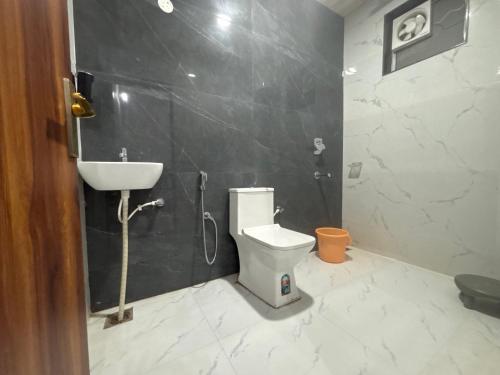 a bathroom with a sink and a toilet and a shower at Lord Krishna hotel in Khātu