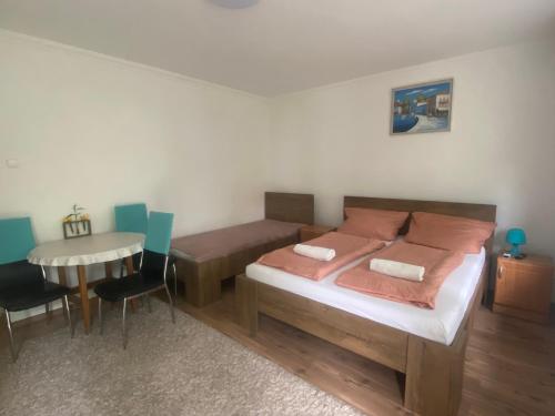 a bedroom with a bed and a table with chairs at Emese Apartman in Hajdúszoboszló