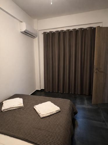 a bedroom with a bed with two towels on it at Serene Stay Kythnos in Flampouria