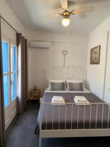 a bedroom with a bed with a ceiling fan at Serene Stay Kythnos in Flampouria
