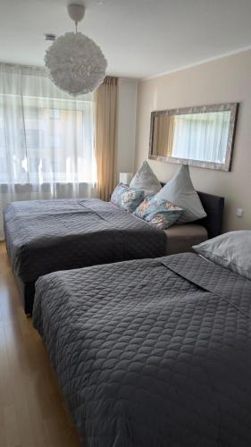 a bedroom with two beds and a large window at 2 Zimmer Ferienwohnung nahe Schweiz in Bad Säckingen