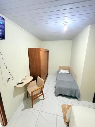 a bedroom with a bed and a desk and a chair at Apartamento do Graf 2 in Sorriso