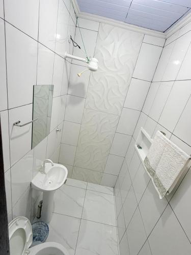 a white bathroom with a toilet and a sink at Apartamento do Graf 2 in Sorriso
