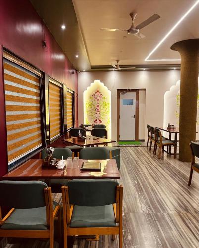 a restaurant with tables and chairs in a room at New Hotel Shree Ganga in Shājāpur