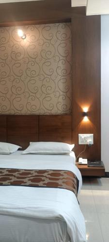 a bedroom with a large bed and a wall with avertisement at New Hotel Shree Ganga in Shājāpur