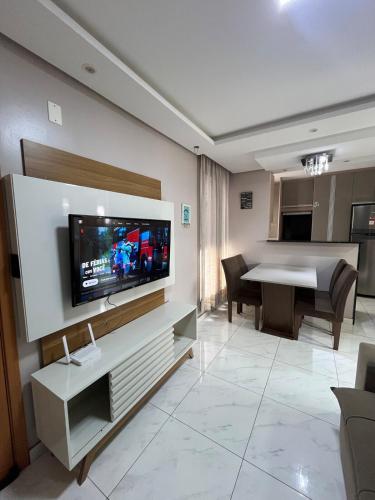 a living room with a television on a wall at 01 Conforto e estilo-piscina e garagem inclusa in São Leopoldo