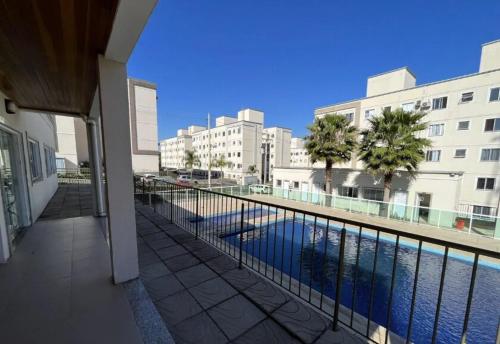 a balcony with a view of a swimming pool with buildings at 01 Conforto e estilo-piscina e garagem inclusa in São Leopoldo