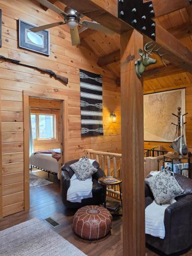 a living room with wooden walls and furniture in a cabin at Cozy Forest Cabin with Hot Tub in Central Flagstaff in Flagstaff