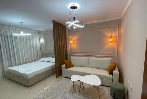 a bedroom with a bed and a couch and a table at Za Apartment 2 in Korçë