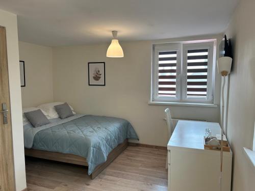 a small bedroom with a bed and a window at Pokoje u Niny in Nowe Rumunki