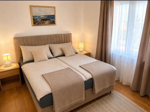 a bedroom with a large bed with two lamps on tables at Apartment A1 Peroj in Peroj