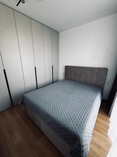 a bedroom with a bed and white walls at Apartment in the city center near park and river 26 in Marijampolė