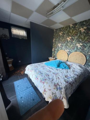 a bedroom with a bed with a floral bedspread at Sab in Beaudreix