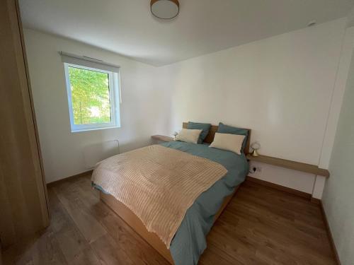 a bedroom with a bed in a room with a window at maison bois in La Forest-Landerneau