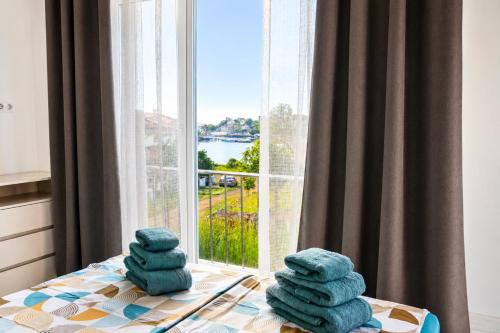 a pile of towels sitting on a table in front of a window at Blu Riviera Deluxe in Ahtopol