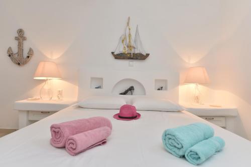 a white bed with three towels on top of it at Yria Holiday Home Paros in Márpissa