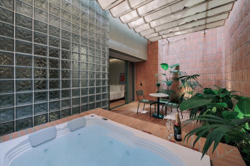 a bath tub in a room with a brick wall at Gres Apartments Medellin in Medellín