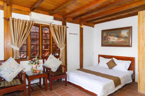 a bedroom with a bed and a table and chairs at Bungalows Hill Mũi Né in Ấp Thiện Long