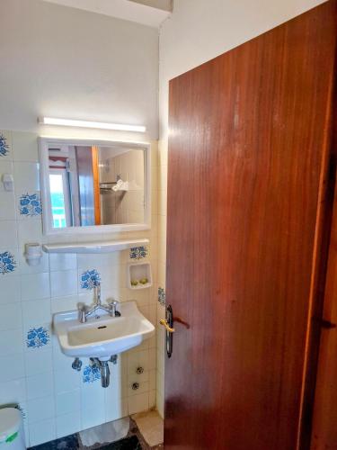 a bathroom with a sink and a wooden door at Lefteris Rooms in Kokkari