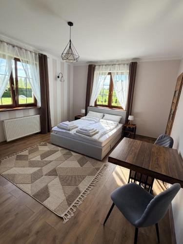 a bedroom with a bed and a table and chairs at Willa Sielanka in Becejły