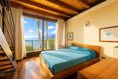 a bedroom with a bed and a large window at La Cami in Torri del Benaco