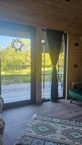 a room with a large sliding glass door with a window at Căsuța din pădure KSIM in Curtea de Argeş