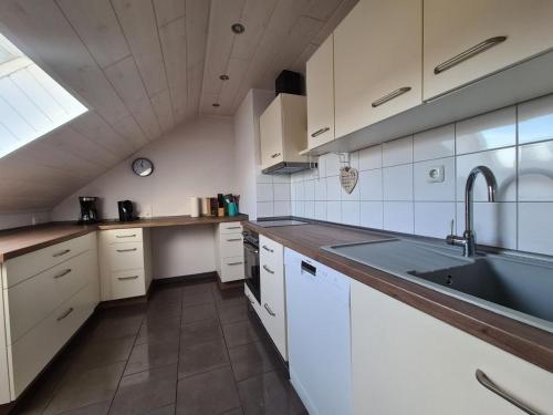 a kitchen with white cabinets and a sink at Fewo Perle Medebach in Medebach