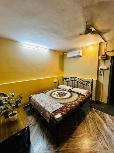 a bedroom with a bed in a room with yellow walls at Sujata Homestay 2 in Ponda