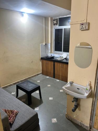 a bathroom with a sink and a mirror and a table at Sujata Homestay 2 in Ponda