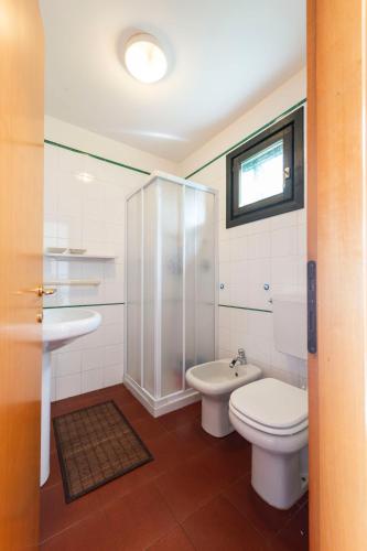 a bathroom with a toilet and a shower and a sink at La Cami in Torri del Benaco