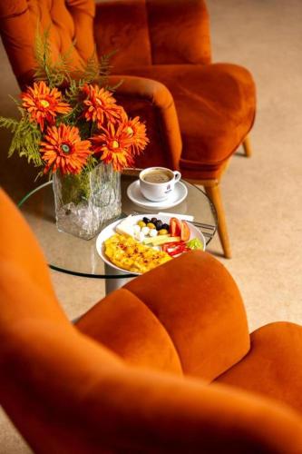a table with a plate of food and flowers on it at Akgun Hotel Beyazit in Istanbul