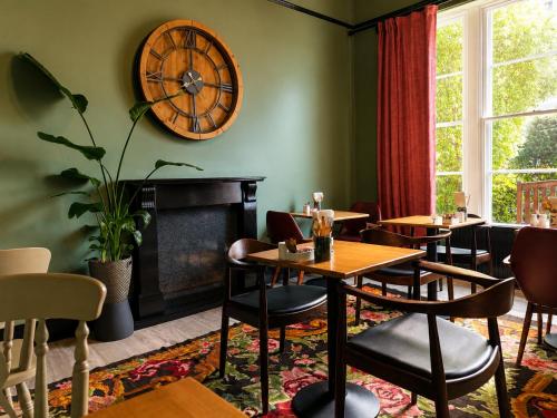 a restaurant with tables and chairs and a clock on the wall at The Mariners - Torquay in Torquay