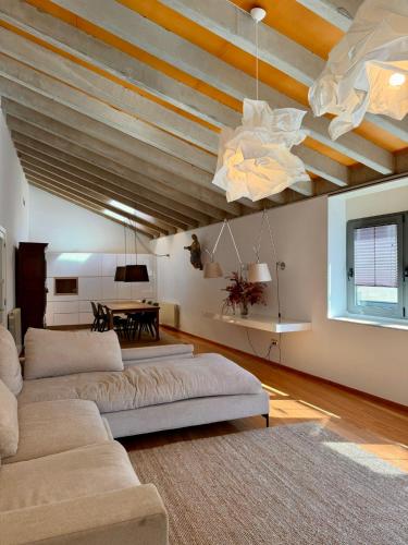 a living room with two couches and a wooden ceiling at La Força Penthouse in Girona