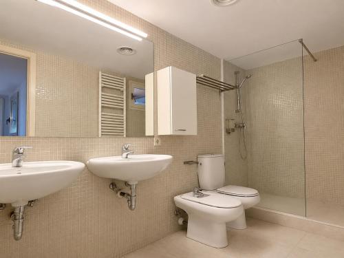 a bathroom with a sink and a toilet and a mirror at La Força Penthouse in Girona