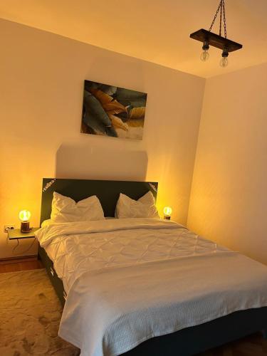 a bedroom with a large bed with white sheets at Wood&Light in Hunedoara