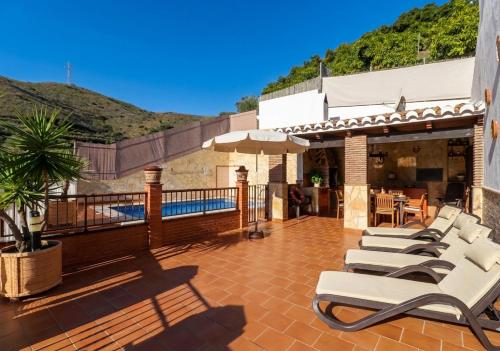a group of chaise lounge chairs on a patio at Villa Alabarce Nerja by Spain Sun Rentals in Nerja