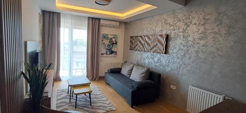 a living room with a blue couch and a window at LuckyCat Apartment in Osijek