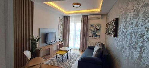a living room with a blue couch and a tv at LuckyCat Apartment in Osijek