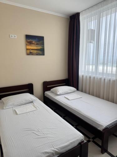 two beds in a room with a window at Asteria in Odesa