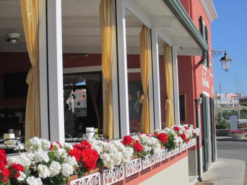 a row of windows with red and white flowers at Al Martin Pescatore in Stintino